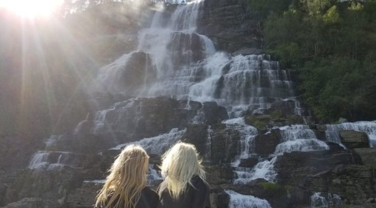 Photo of two children looking at beautiful cascading waterfall