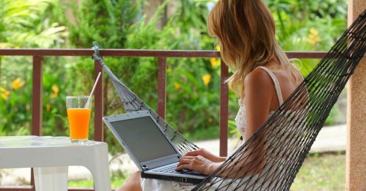 Picture of woman working on laptop in hammock