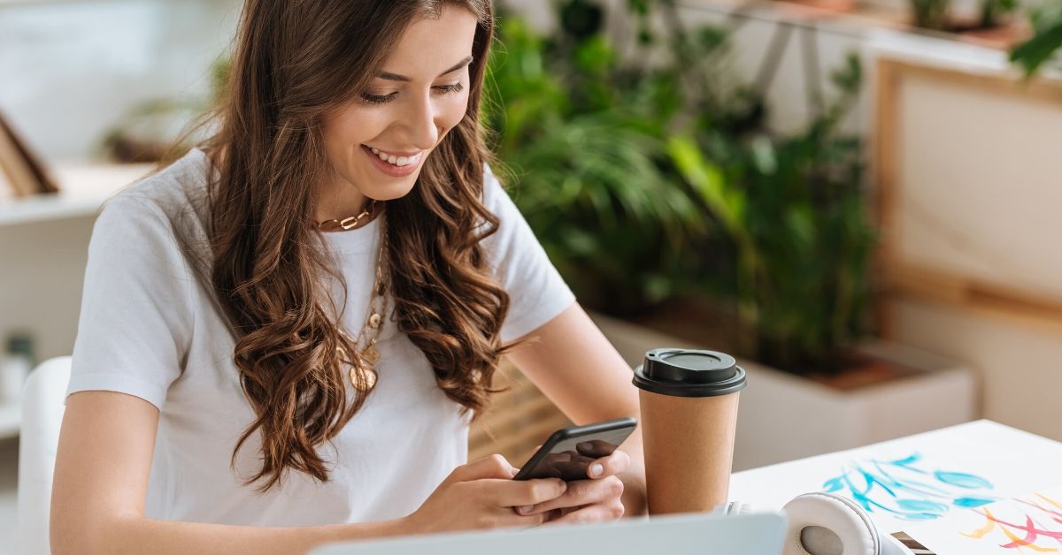 Credible Personal Loans Review - picture of young woman smiling at her phone